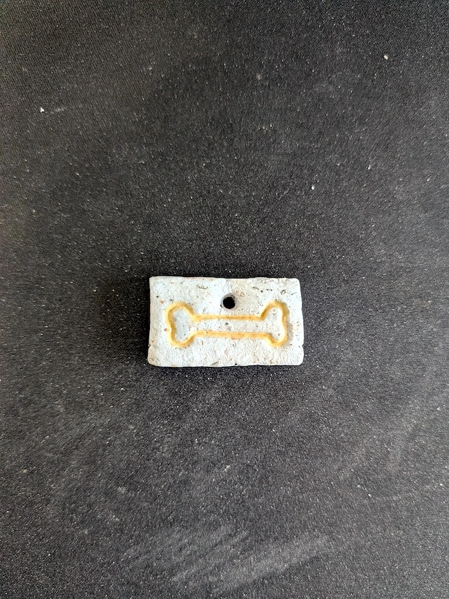 A clay trinket with a bone imprint